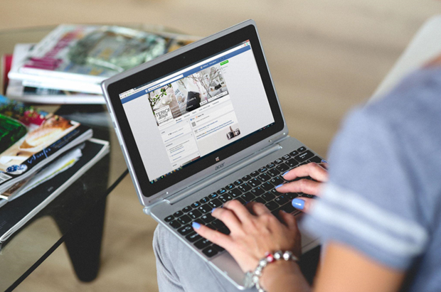 Person browsing Facebook on a laptop