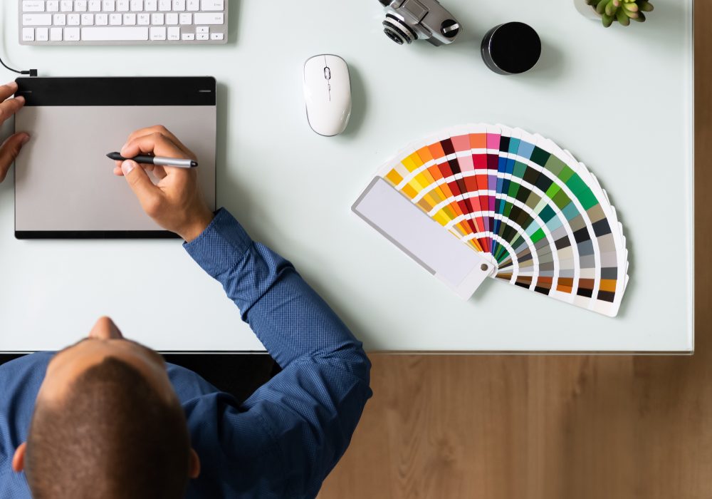 Man sitting at a desk choosing colours for a website design